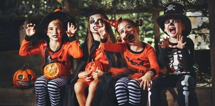 Copii care stau în costume de Halloween